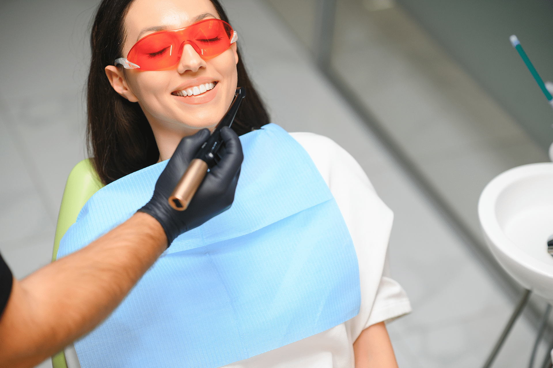 Patient wearing orange eye protective gear at Aura Dental Clinic during a dental procedure.
