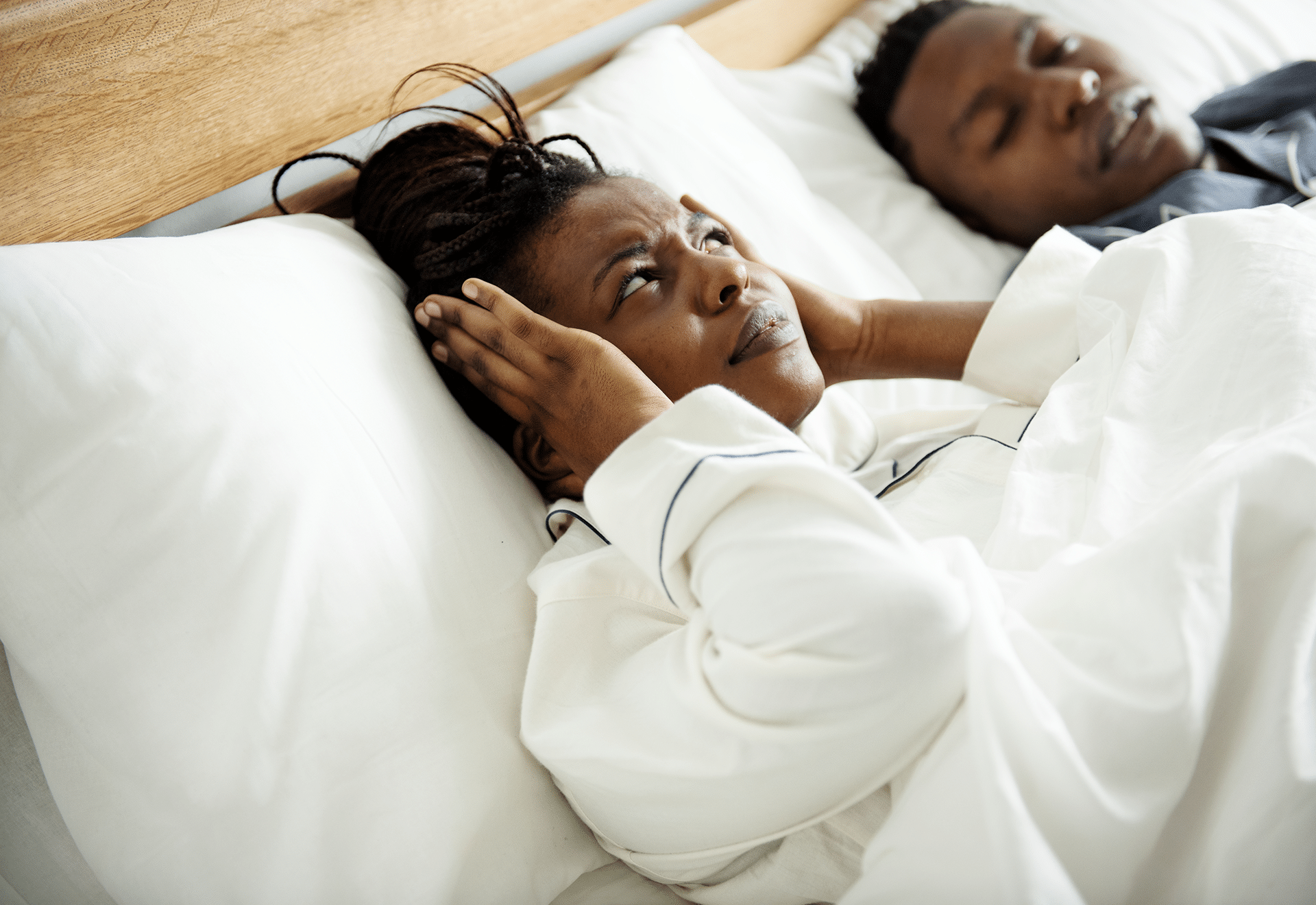 Woman struggling to sleep due to sleep apnea, depicted in a serene dental clinic environment at Aura Dental Clinic.