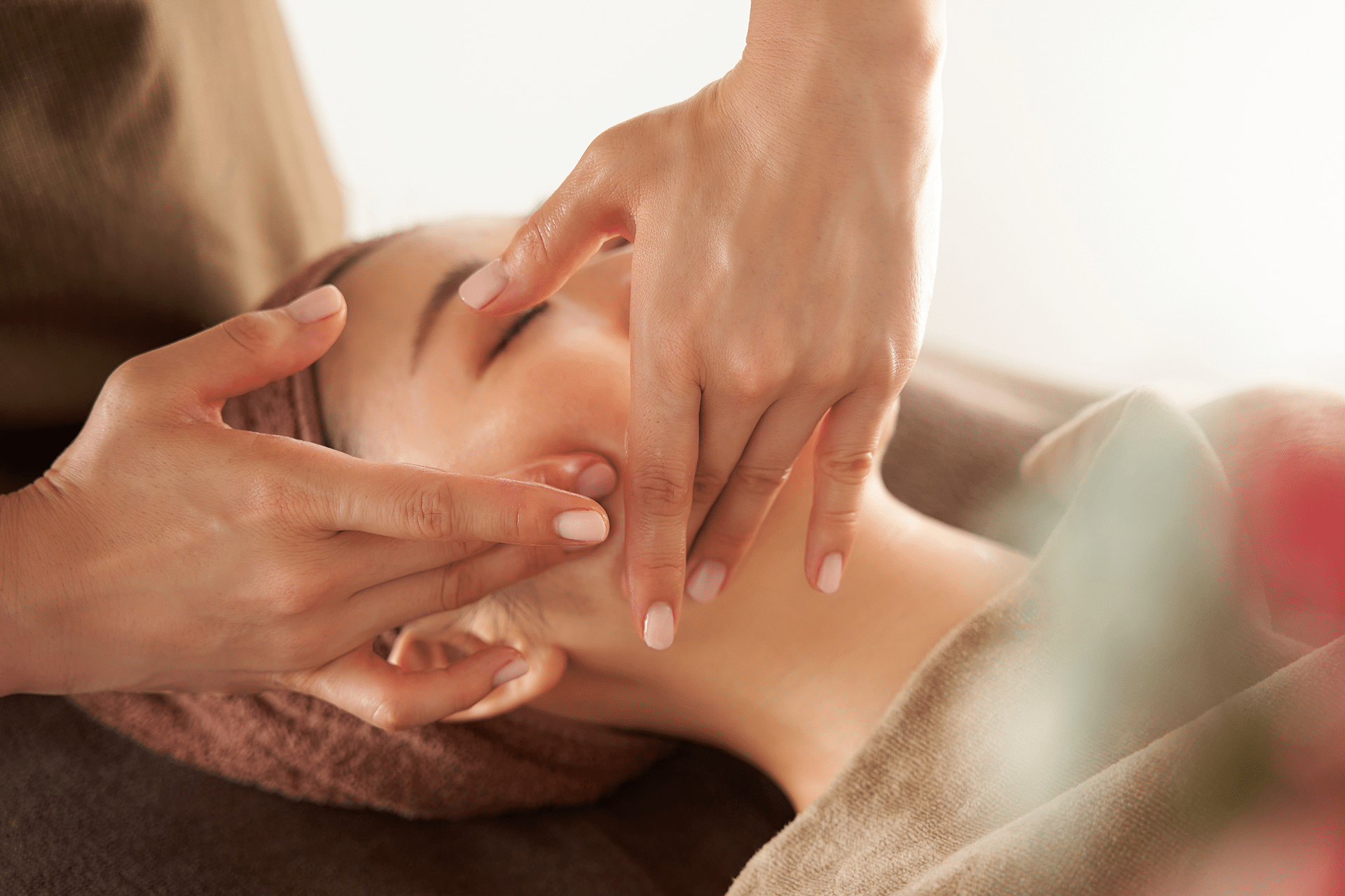 Woman receiving a facial massage at Aura Dental Clinic, promoting relaxation and wellness in a serene environment.