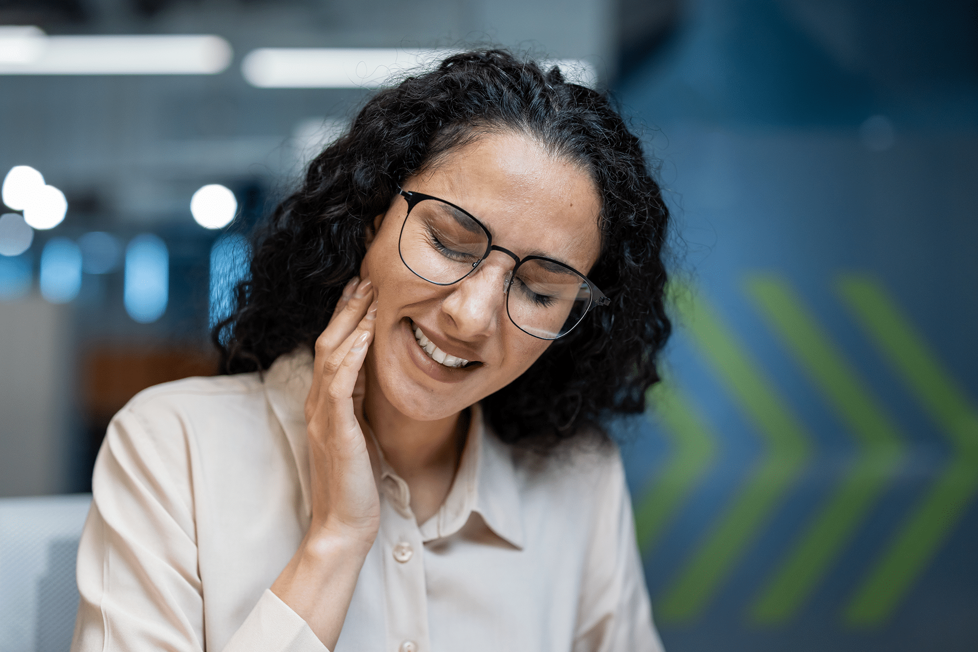 A woman in an office grimaces, holding her jaw, indicating a toothache, with a sign for Aura Dental Clinic in the background.