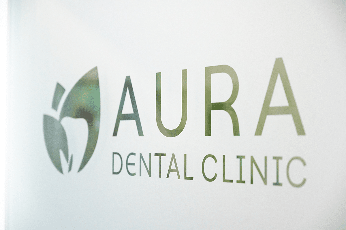 Aura Dental Clinic logo displayed on the clinic wall, featuring a modern design with dental imagery and the clinic name.